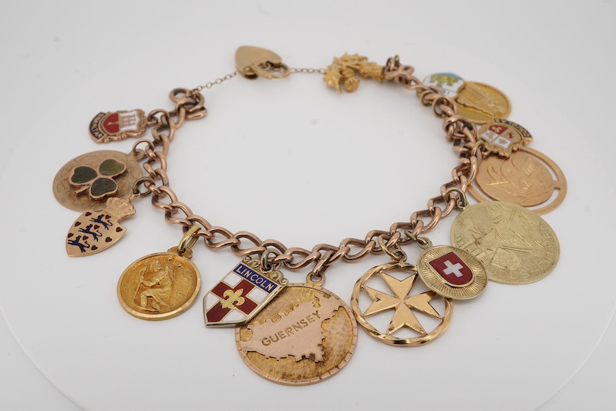 A 9ct gold charm bracelet, with heart shaped clasp, hung with fourteen assorted charms including five 9ct, two 14k and two 18k and five unmarked, gross weight 39 grams. Condition - fair